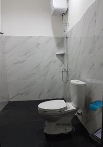 bagno con servizi igienici bianchi in camera di Rumah Benhil, Bendungan Hilir - Senayan a Giacarta
