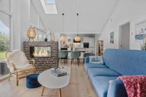 a living room with a blue couch and a fireplace at N329-Karrebaeksminde-Krageholmsvej-58 in Enø By