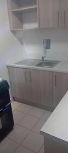 a white kitchen with a sink and a counter at Hillfort Hostel in Baltinglass
