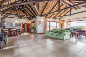 ein Wohnzimmer mit einer grünen Couch und einem Tisch in der Unterkunft Waterberg House at Zebula - 8 adults and 4 kids under 10 years in Mabula