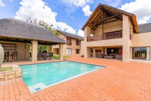 ein Swimmingpool im Hinterhof eines Hauses in der Unterkunft Waterberg House at Zebula - 8 adults and 4 kids under 10 years in Mabula