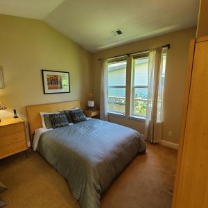 ein Schlafzimmer mit einem Bett und einem großen Fenster in der Unterkunft Zen by the River-3 bedroom 2 bath hot tub in Monte Rio