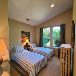 ein Schlafzimmer mit zwei Betten und einem Fenster in der Unterkunft Zen by the River-3 bedroom 2 bath hot tub in Monte Rio