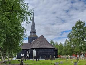 a church with a tall steeple on a cemetery at Centrally located holiday home in Stöllet in Stöllet +14 photos