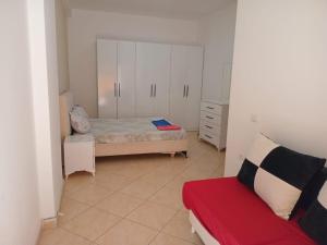 Un dormitorio con una cama y un sofá rojo. en Tag HOSTEL, en Tirana