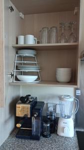 a kitchen counter with a blender and dishes on a shelf at Spacious Cheltenham Flat with Free Allocated Parking in Cheltenham