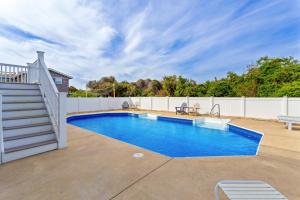 a swimming pool in a backyard with a white fence at 3054 - Latitude Adjustment in Southern Shores
