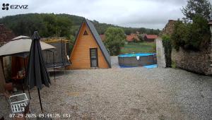 a small house with a swimming pool in a yard at A Frame Halmeag in Hălmeag +2 photos