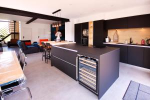 a kitchen with black cabinets and an open refrigerator at Grange rénovée- 3 chambres spa in Basly