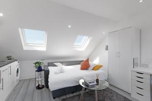 ハーロウにあるCity Apartment - Sleeps 4 & Free Parkingの白いベッドルーム(ベッド1台、テーブル付)