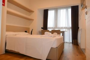 a hotel room with two beds with towels on them at SILVANELLO Apartment in Trento