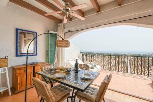 a dining room with a table and chairs on a balcony at Casa BuenaVista Calpe in Casas de Torrat