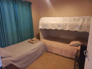 a bedroom with two twin beds with blue curtains at Verde Encanto in Siambón