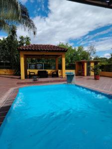 a large blue swimming pool with a gazebo at Espectacular Casa vacacional -Piscina privada in Agua de Dios
