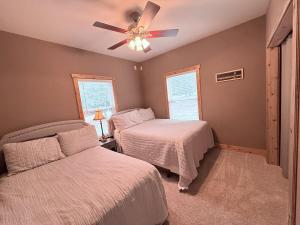 a bedroom with two beds and a ceiling fan at Carlene's Place in Kingston