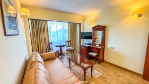 un soggiorno con divano e scrivania di Hotel Germisara a Geoagiu Băi