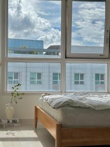 Cama en habitación con 2 ventanas grandes en Calming place, Seoul #4, en Seúl