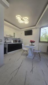 una cucina con un tavolo bianco e sedie in una stanza di Cozy 2-Bedroom Apartment with Private Balcony- SELF CHECK-IN a Bucarest