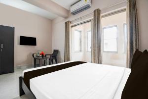 a bedroom with a white bed and a window at Hotel O Aasiyanaa Guest House in Bhubaneshwar +20 photos
