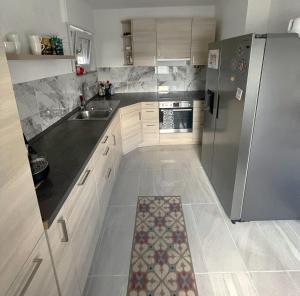 a kitchen with white cabinets and a stainless steel refrigerator at WohnZeit Warstein in Warstein +5 photos