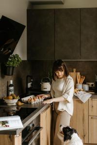 a woman standing in a kitchen preparing food at BURSZTYNOWA-PRZYSTAŃ in Lubiatowo +81 photos