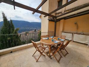 a wooden table and chairs on a balcony at Apartment in Bargemon in Bargemon