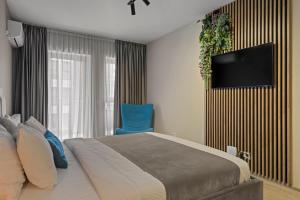 a bedroom with a bed and a tv on a wall at Studio 6 in Bucharest