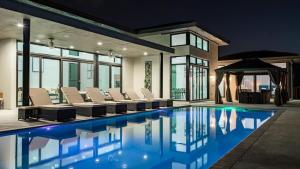 a swimming pool with chairs and a gazebo at The Mansion One and Only Luxurios 8 000 ft Villa in Melalevca Isles