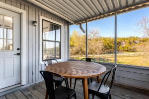 a wooden table and chairs on a porch with a table and windows at Mountain Top Retreat in Canyon Lake