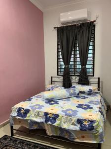 een slaapkamer met een bed met een bloemdekbed bij CozyInn Homestay 4 in Kampong Lanjut Manis +19 foto's