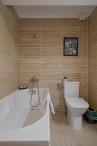 a bathroom with a white tub and a toilet at Studio 6 in Bucharest +26 photos