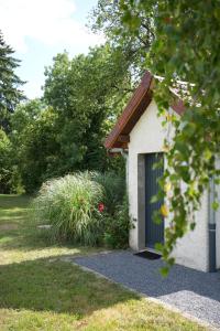 a garage with a blue door in a yard at TREE LODGY - LINAE - Nouveau espace bien être disponible in Ray-sur-Saône +24 photos