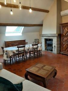 Dun-les-PlacesにあるMaison des tilleulsのテーブルと暖炉のあるダイニングルーム