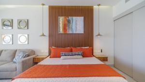 佩尼亚斯科港Luxury Studio with King Bed Oceanview Terrace at Sonoran Star Resort的一间卧室配有带橙色枕头的床和沙发 更多20张照片