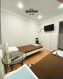 a small room with a bed and a glass table at Qaragai hostel in Uralsk +24 photos
