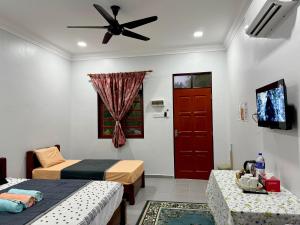 a room with two beds and a red door at AL-REZQI RoomStay in Marang