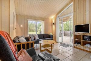 uma sala de estar com um sofá e uma TV em JB699-Fjerritslev-Revlingestien-43 em Torup Strand