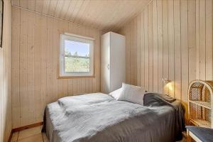 um pequeno quarto com uma cama e uma janela em JB699-Fjerritslev-Revlingestien-43 em Torup Strand