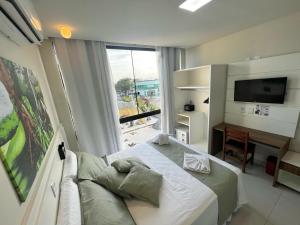 a bedroom with a bed and a large window at Hotel Recanto dos Dinossauros in Penha +91 photos