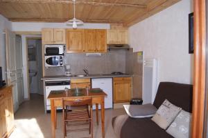 a small kitchen with a table and a couch at Appartement la Cascade in Allos