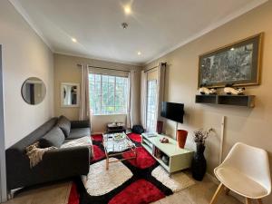 a living room with a couch and a table at Cotswold Sanctuary in Johannesburg