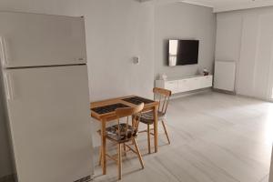 a kitchen with a table and two chairs and a refrigerator at Comfort Corner Spacious & Quiet 2BR Apartment in Thessaloniki in Thessaloniki