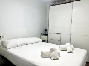 ムルシアにあるApartment next to Hospital Morales Meseguerの白いベッドルーム(ベッドにタオル2枚付)