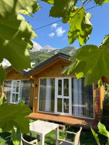 a log cabin with a table and chairs at Thethi Mountain Villas in Theth