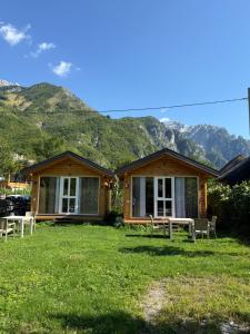 a log cabin with mountains in the background at Thethi Mountain Villas in Theth