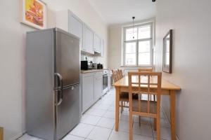 a kitchen with a table and a stainless steel refrigerator at 12 guests, 70m2, center of Old Town, Wi-Fi, Streaming in Tallinn