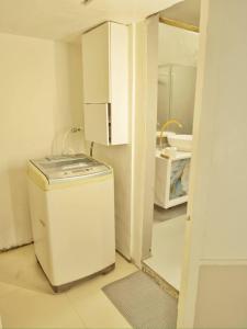 a small kitchen with a washer and a sink at Clear Mountains Properties in Kharakvasla