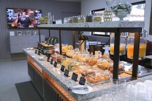 una linea a buffet con molti tipi diversi di cibo di Hotel & Pousada Porto Ubá a Lidianópolis
