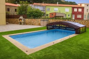 a swimming pool in the yard of a house at Casa El Rincón de Alberto con Piscina CLIMATIZADA y Calefacción in Camelle