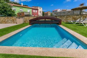 a swimming pool in a yard with a wooden bridge at Casa El Rincón de Alberto con Piscina CLIMATIZADA y Calefacción in Camelle